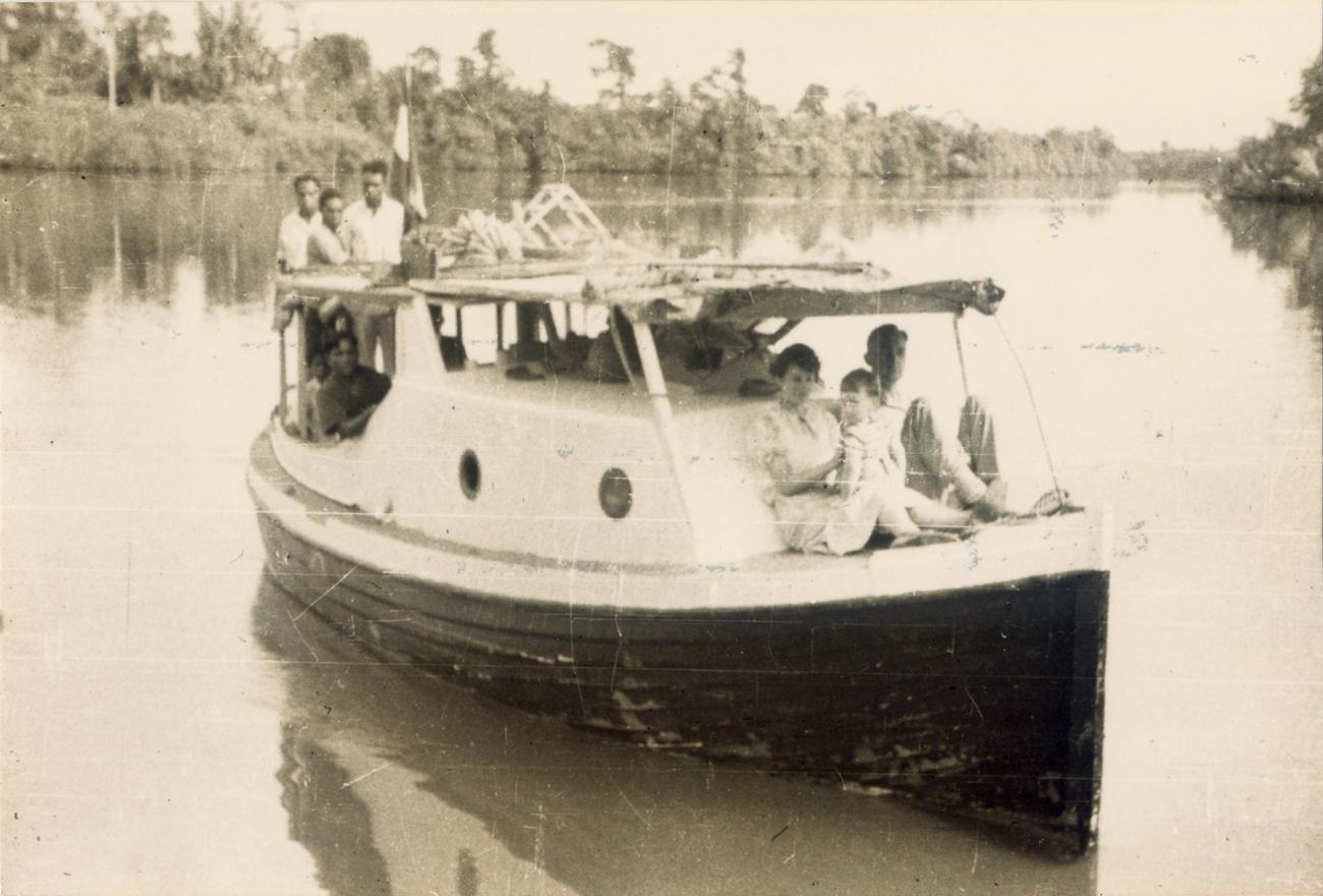 BD/309/13 -
De familie Messie op voorplecht schip, varend op de rivier