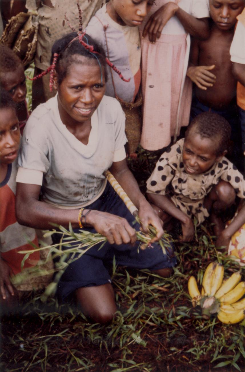 BD/309/82 -
Dorp Bogor, vrouw omringd door kinderen op markt. Niet publiceren, niet in Nieuw Guinea