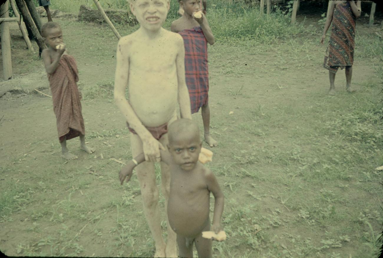 BD/144/266 - 
Groepsfoto papoea-kinderen die stuk brood eten

