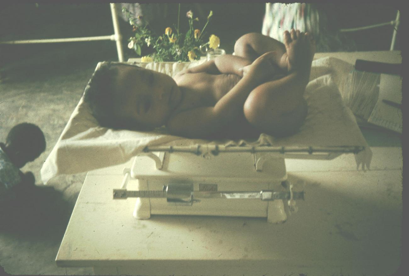 BD/144/326 - 
Polikliniek, baby wordt gewogen
