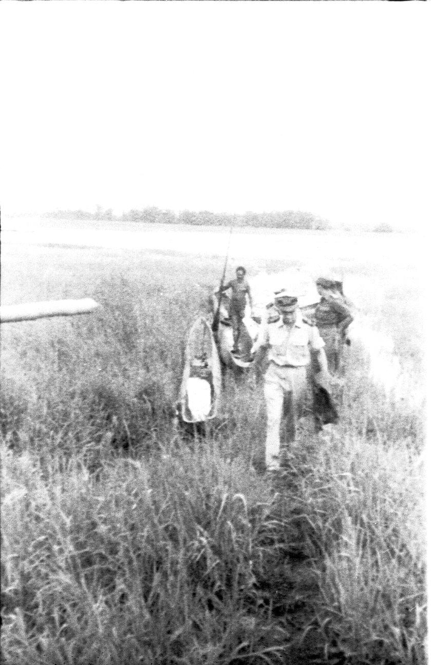 BD/67/237 - 
People on the road crossing water with reed
