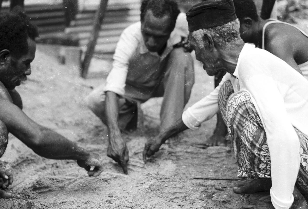 BD/133/1184 -
Papoea-mannen tekenen een kaart in het zand