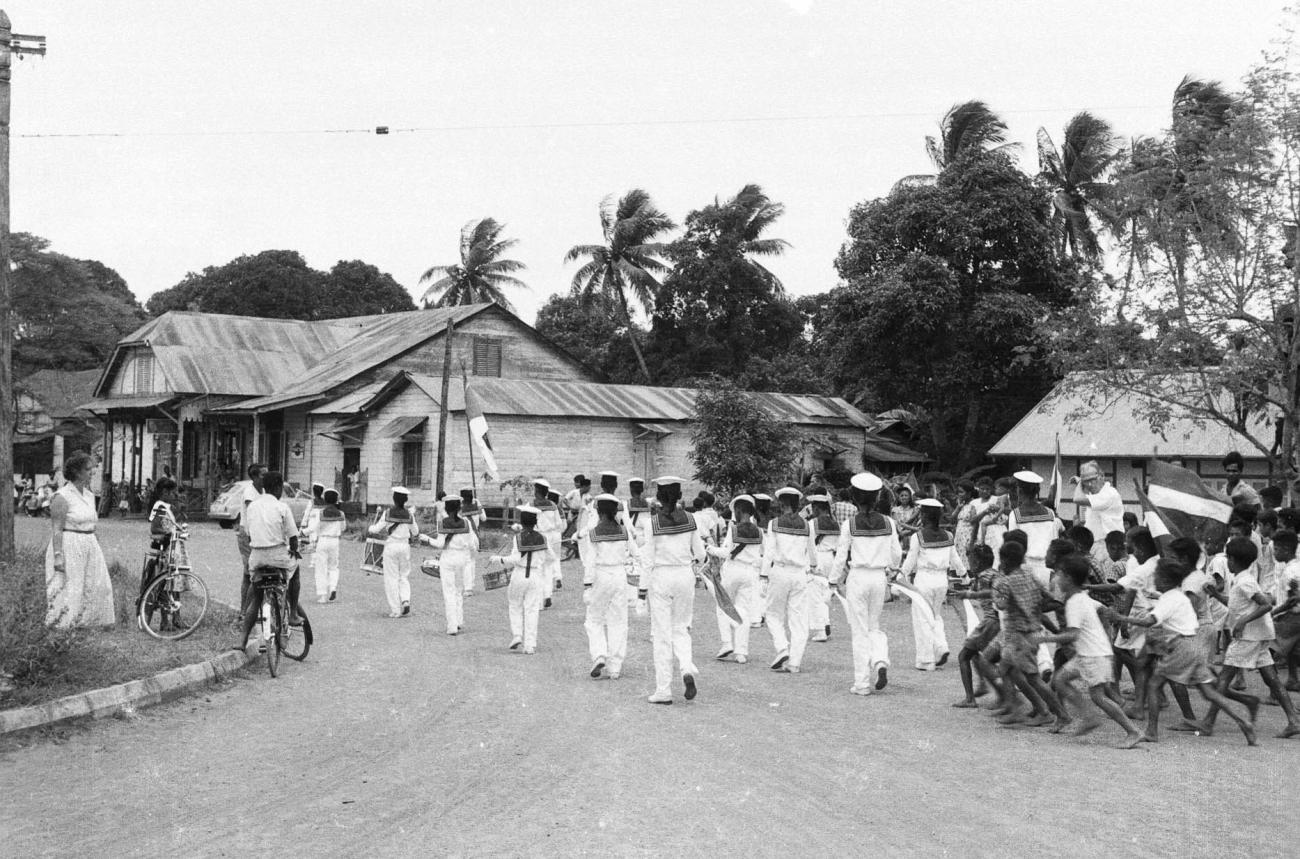 BD/133/19 - 
Marching band followed by a group of children
