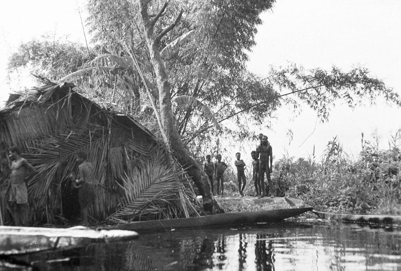BD/133/291 -
Tocht Merauke-Kepi-Cook: Hut met prauwen aan het water