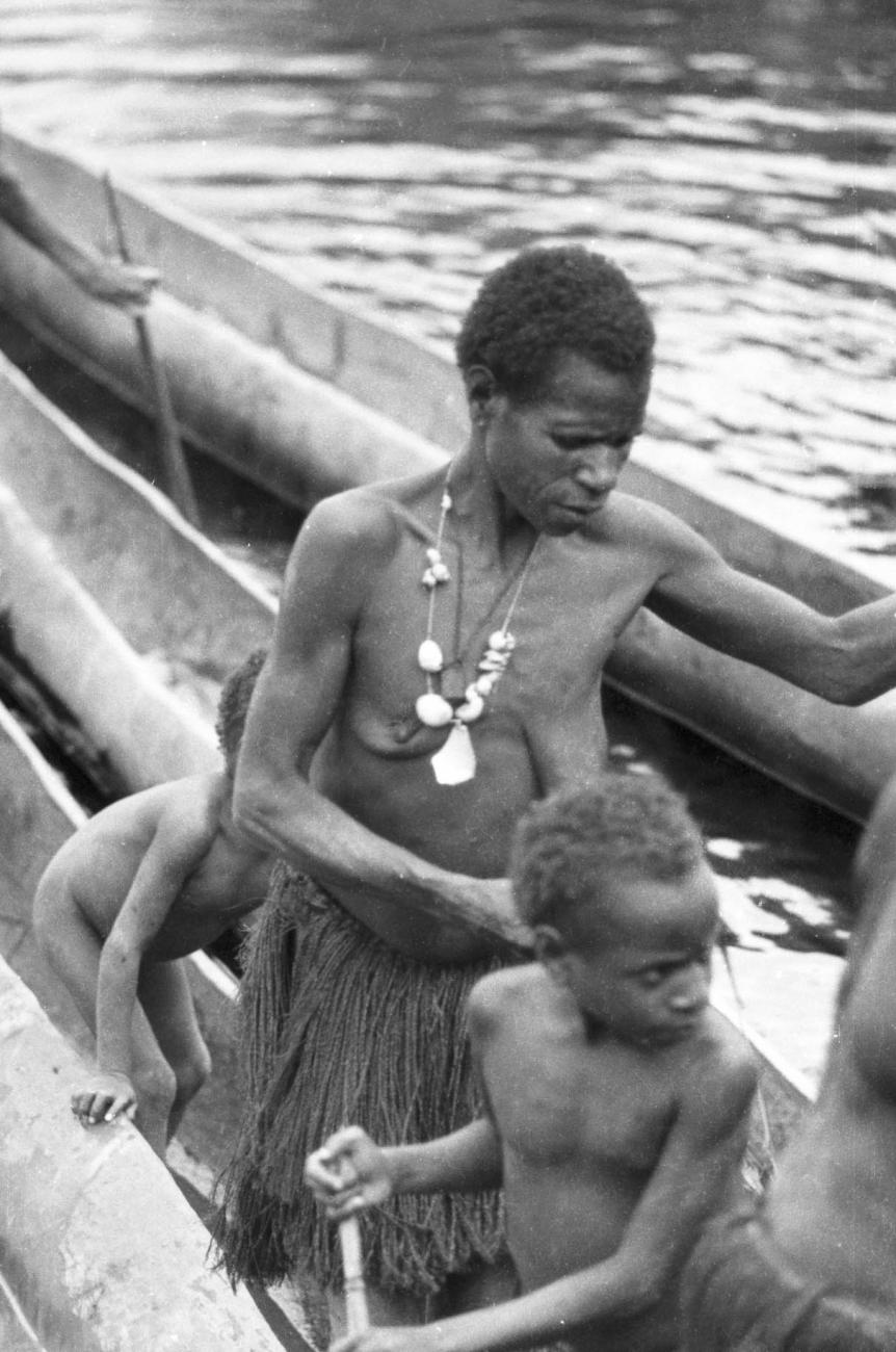 BD/133/426 -
Tocht Merauke-Kepi-Cookrivier vv: Vrouw met kinderen in een prauw