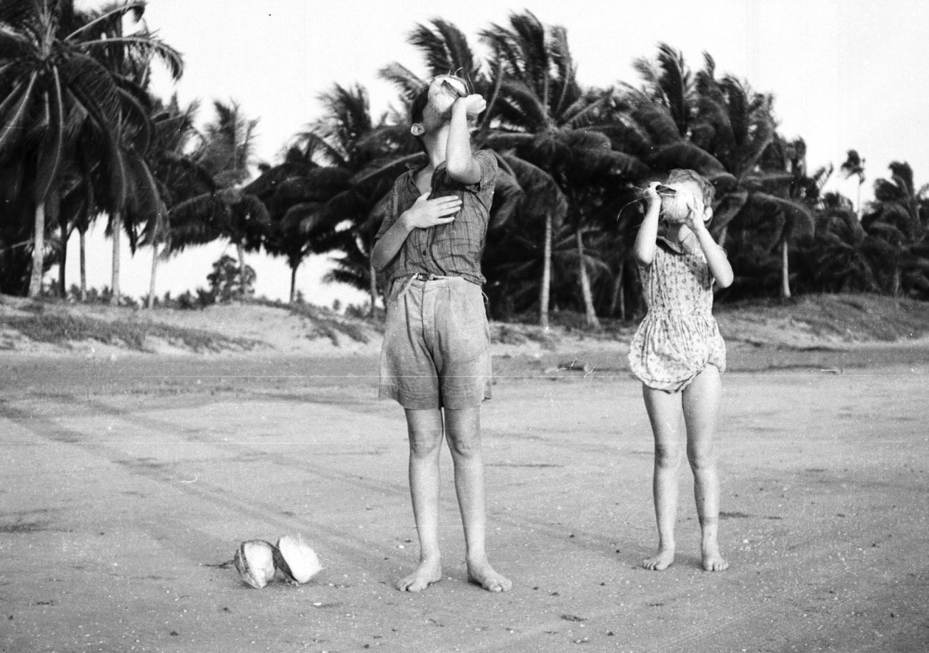 BD/133/833 -
Westerse kinderen drinken kokosnootmelk op het strand