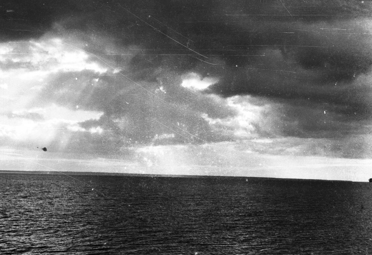 BD/133/855 -
Kalme zee met kustlijn en donkere wolken