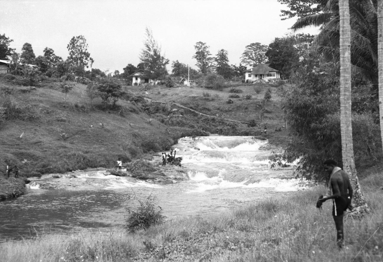 BD/133/907 -
Rivier met stroomversnellingen bij een nederzetting