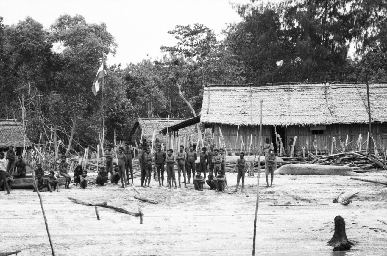 BD/133/975 -
Nederzetting aan de rivier met groep Asmat
