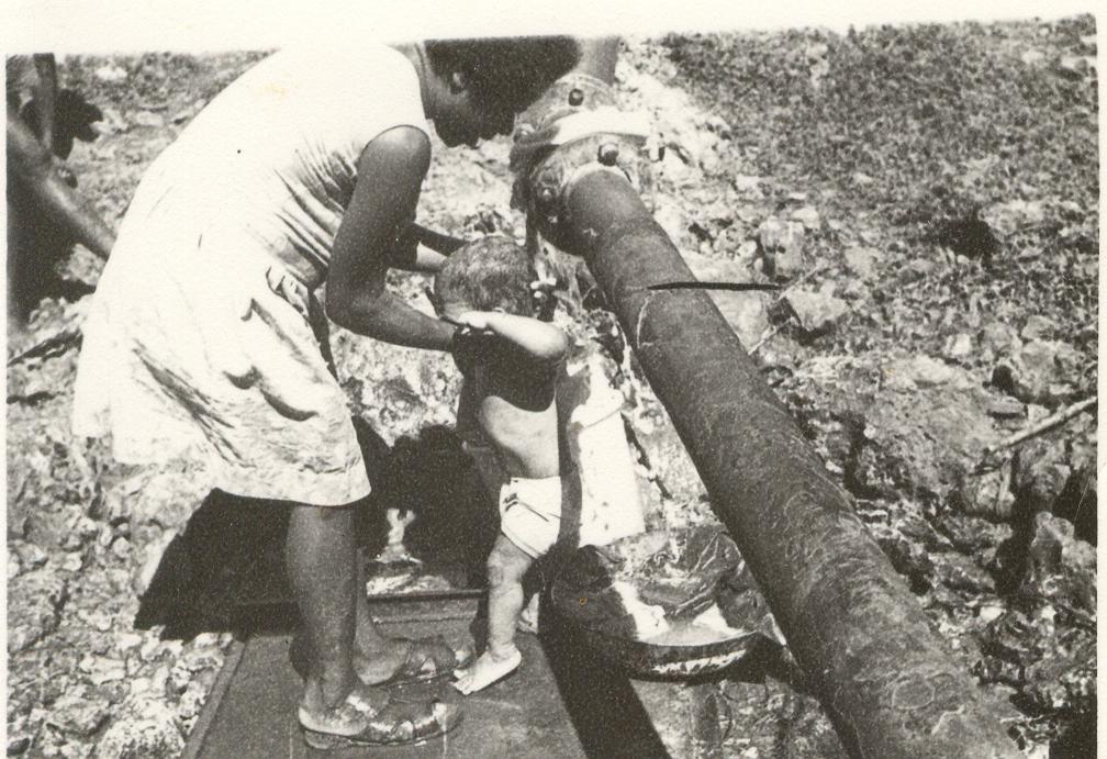 BD/253/41 -
Vrouw met kind bij waterleidingspijp