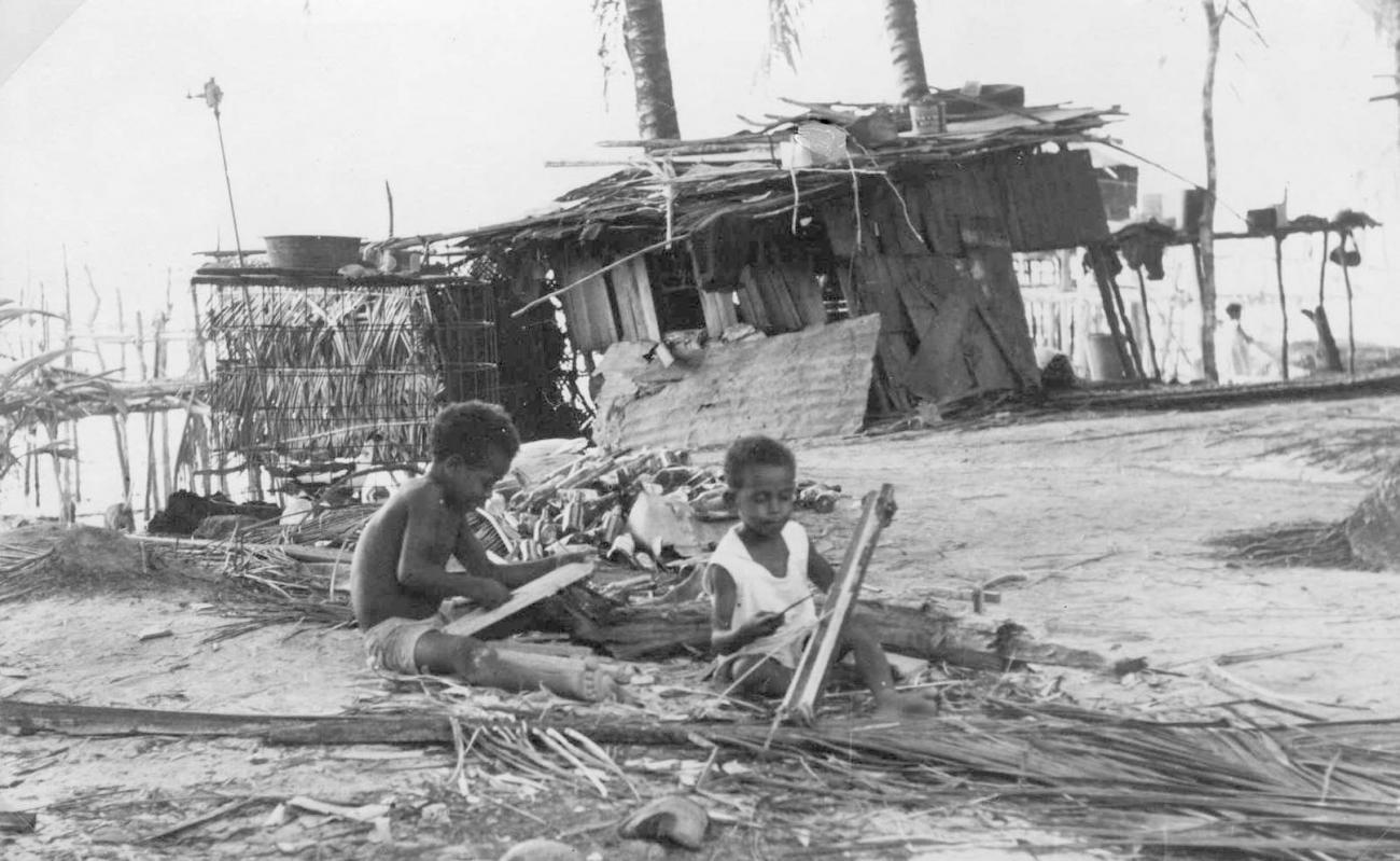 BD/277/76 -
Twee kinderen op het strand bij een huis
