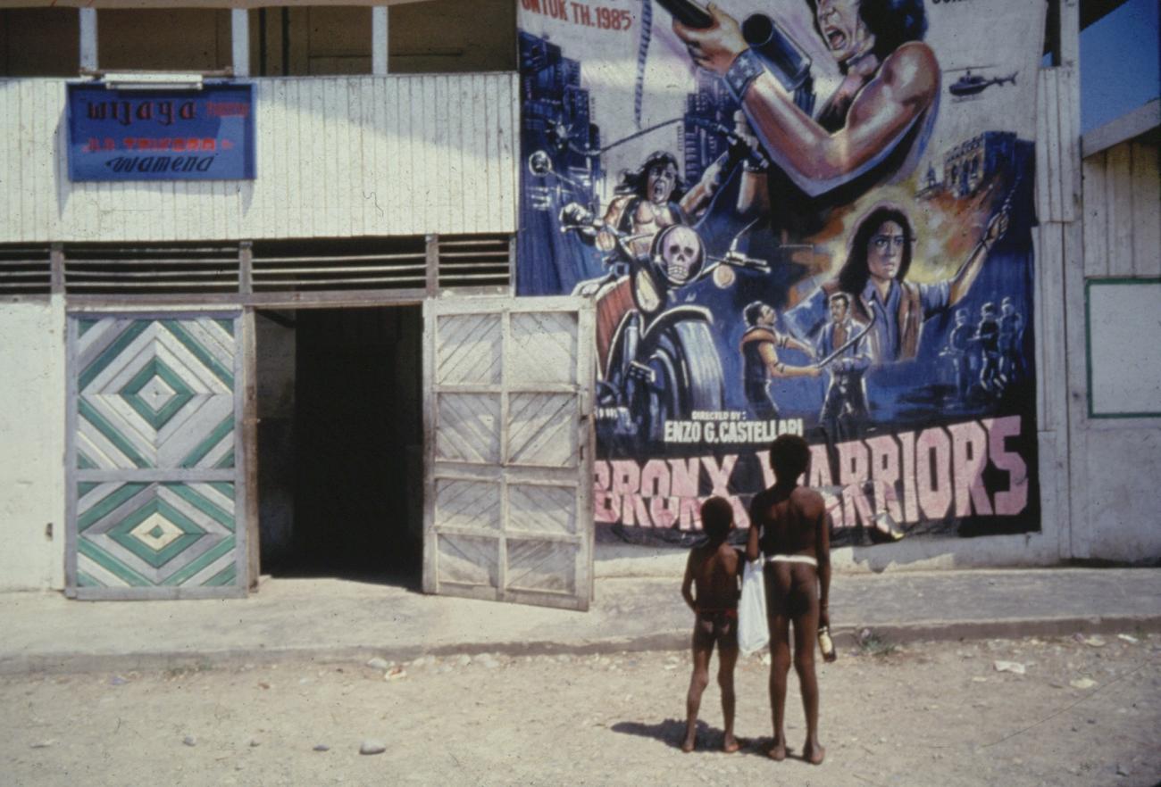 BD/285/79 -
Twee Dani-jongetjes kijken naar een grote filmposter bij een bioscoop in Wamena