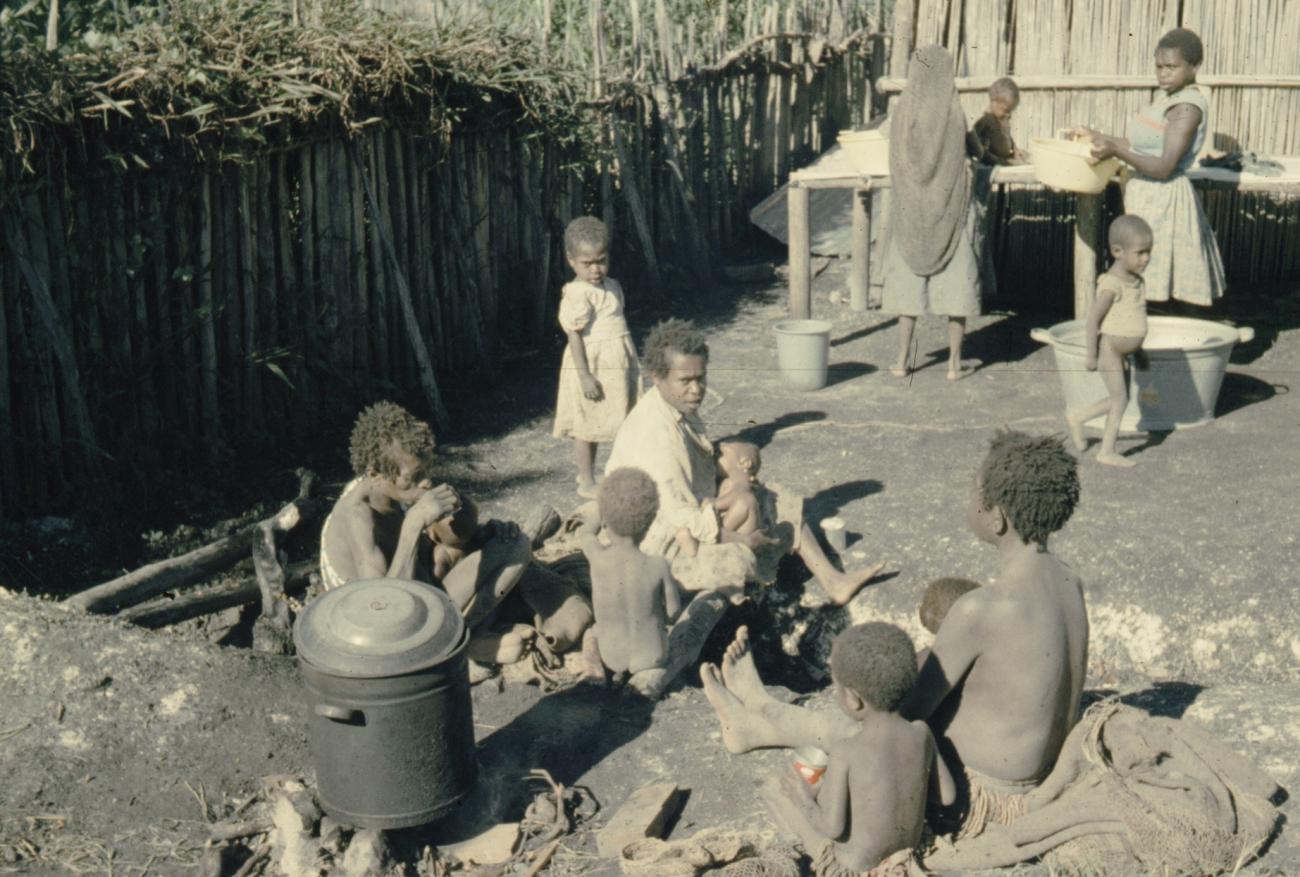 BD/285/86 -
Ekari-vrouwen maken kinderen schoon en vrouw voedt baby