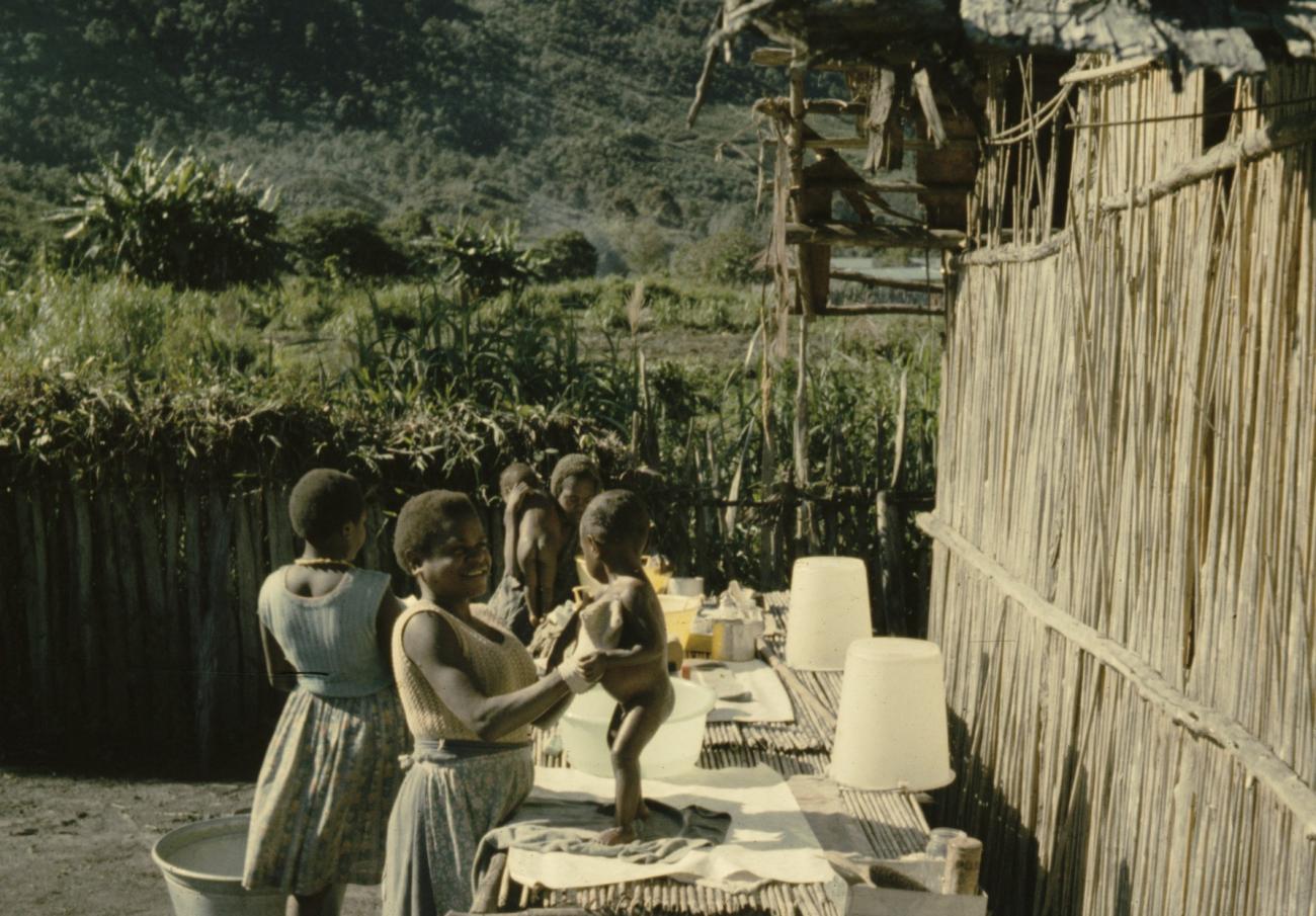 BD/285/90 -
Vrouwen maken kinderen schoon aan tafel