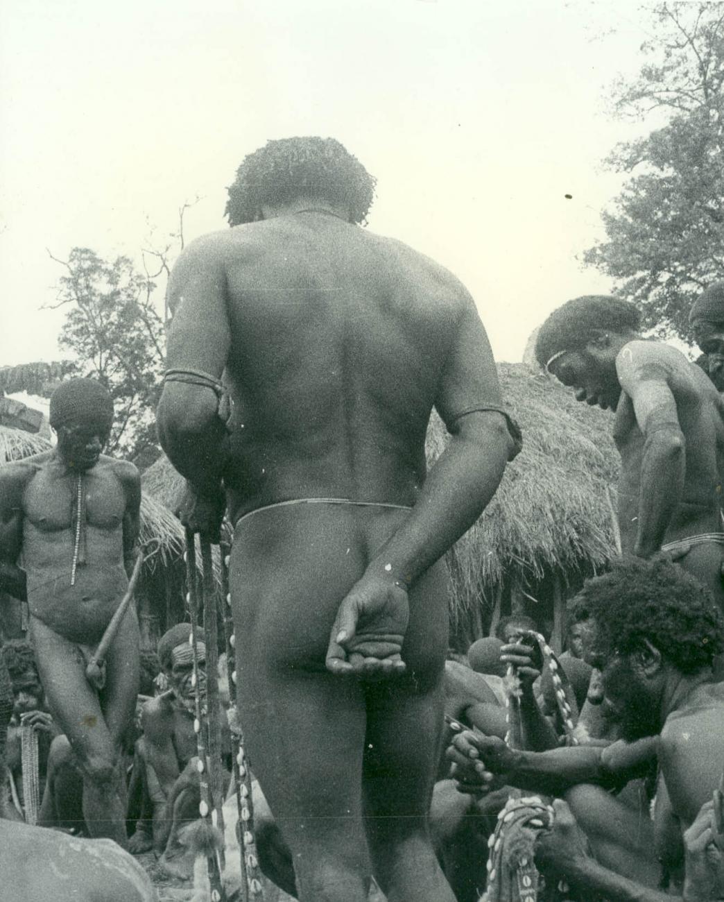 BD/40/68 -
Mountainland inhabitants with penis gourd checking shell strings