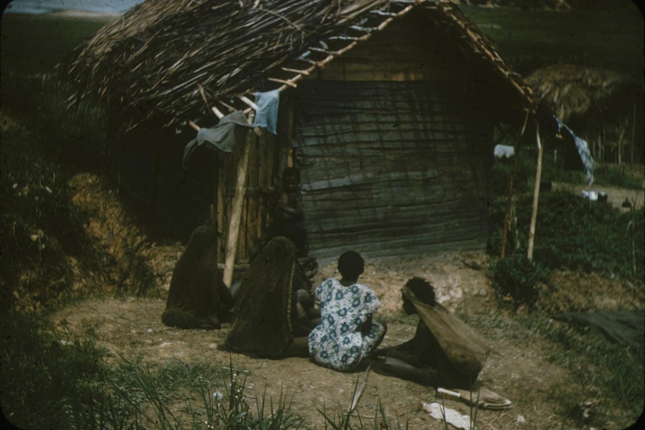 BD/248/252 -
Berglandbewoners zittende voor een huis, van achteren gefotografeerd