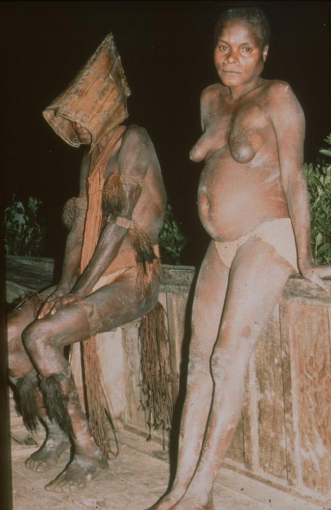 BD/30/74 -
Asmat women in mourning cloths sitting on a veranda at night