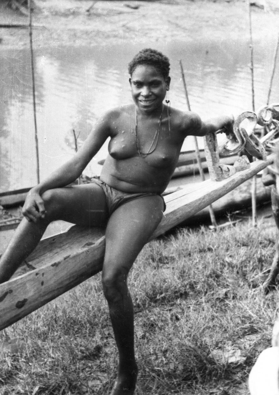 BD/66/420 - 
Vrouw  uit de Asmat leunt tegen prauwsteven
