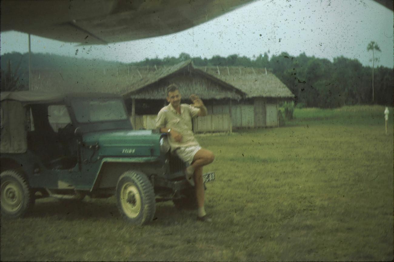BD/171/249 -
Westerse man poseert voor jeep op luchthaven.