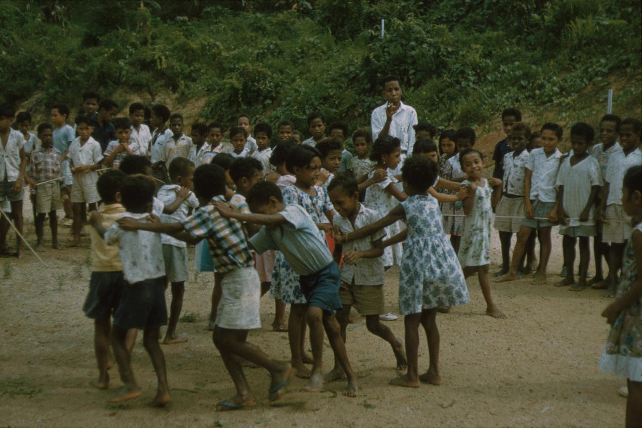BD/171/707 - 
Kinderen doen de polonaise met leraar erbij
