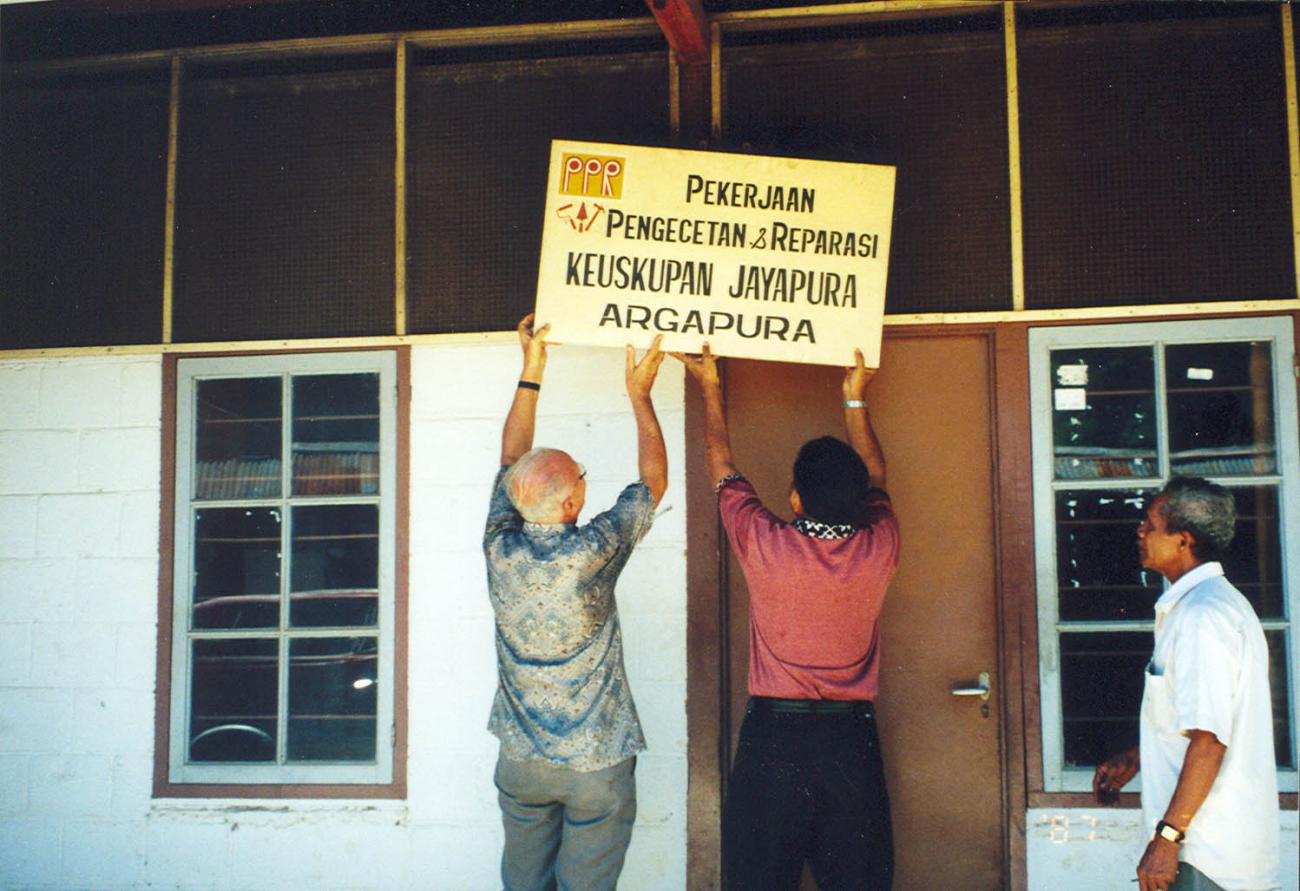 BD/269/1104 -
Henk Blom hangt samen met iemand bord van PPR op