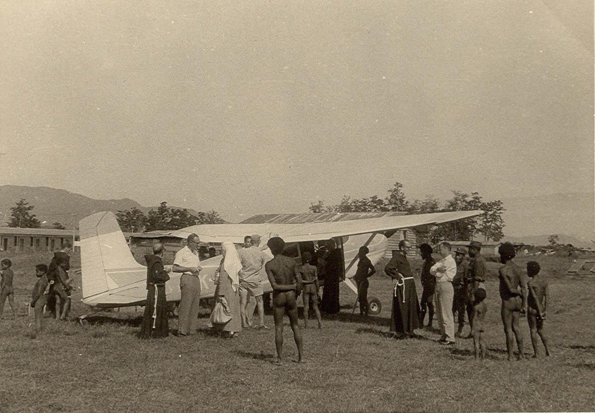 BD/269/1229 -
Franciskaner broeders, zuster en papoea's verzameld rondom Cessna