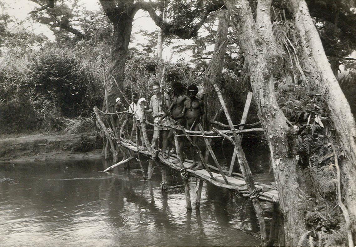 BD/269/1248 -
Franciscaan en Papoea's op loopbrug over rivier