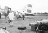 BD/133/741 Airstrip met vliegtuig, fiets en (westerse) passagiers