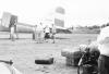 BD/133/742 Airstrip met vliegtuig, fiets en (westerse) passagiers