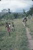 BD/171/264 Vrouw met draagtas en kinderen lopen over zandpad 