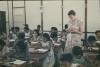 BD/171/671 Schoollerares met kinderen in schoolbanken